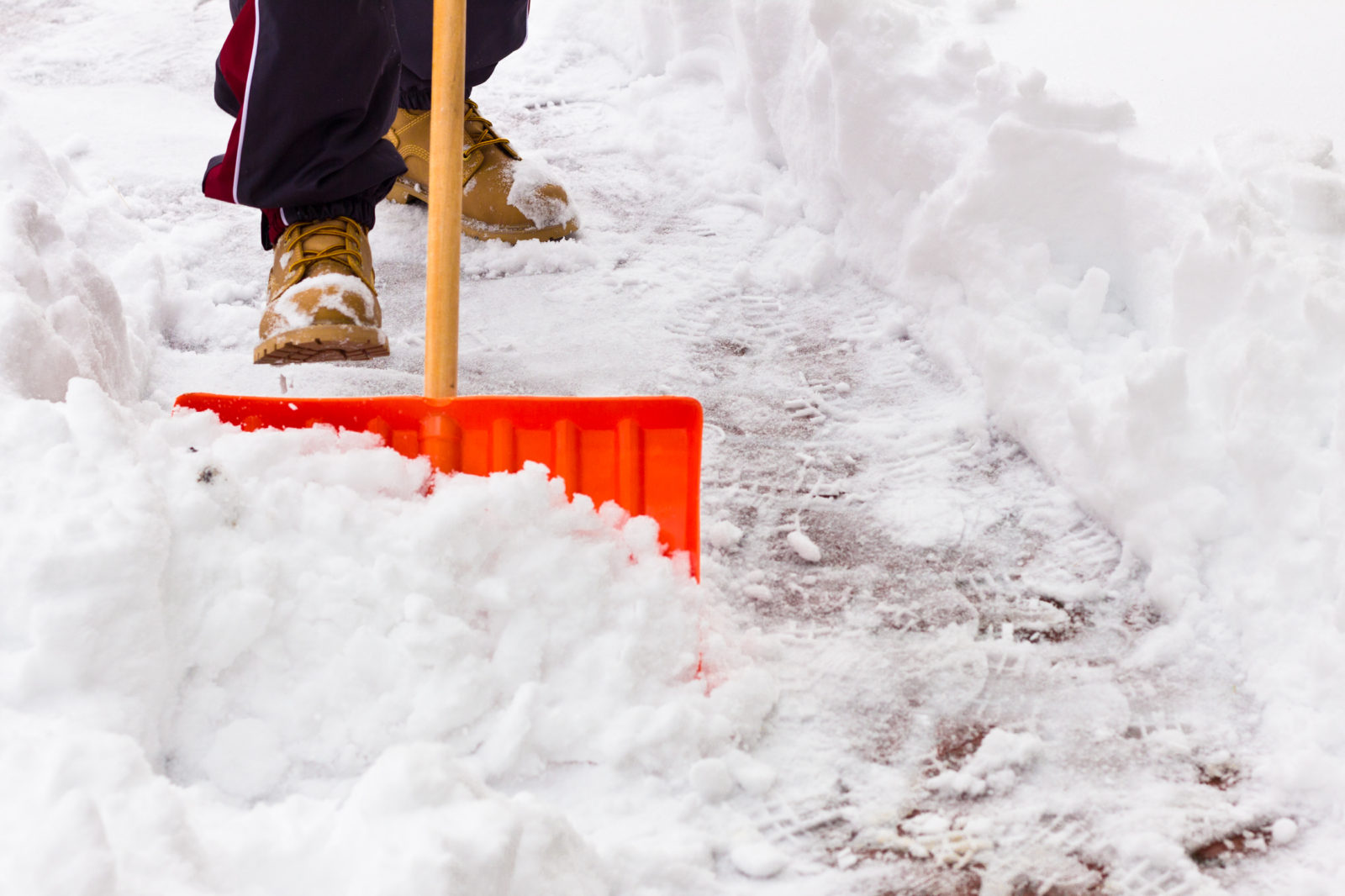 A picture of someone shoveling snow from a sidewalk, to illustrate a winter storm alert post. LCA