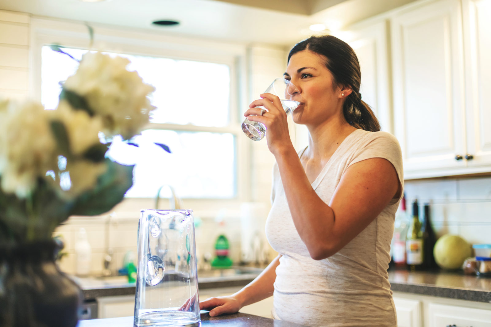 A photo of a woman drinking tap water, to illustrate the post "Drinking water quality reports are available."