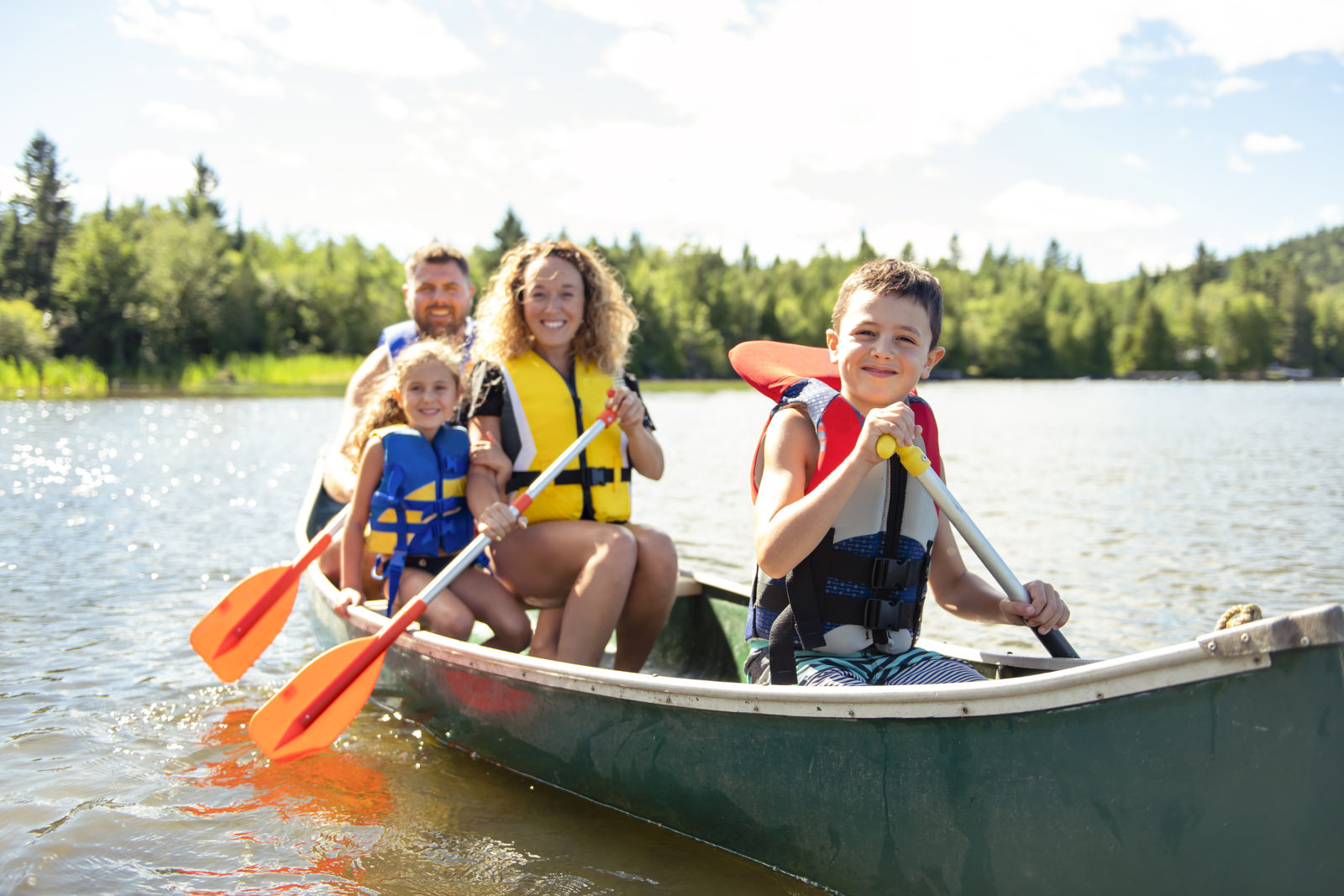 A family in a canoe on a lake. Make water safety your priority. LCA