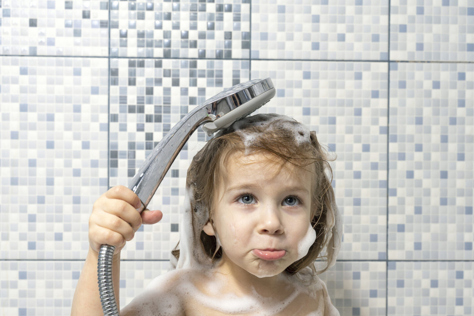 A child in the shower with a soapy head cannot rinse because the water stopped, for a post on Imagine a day without water.