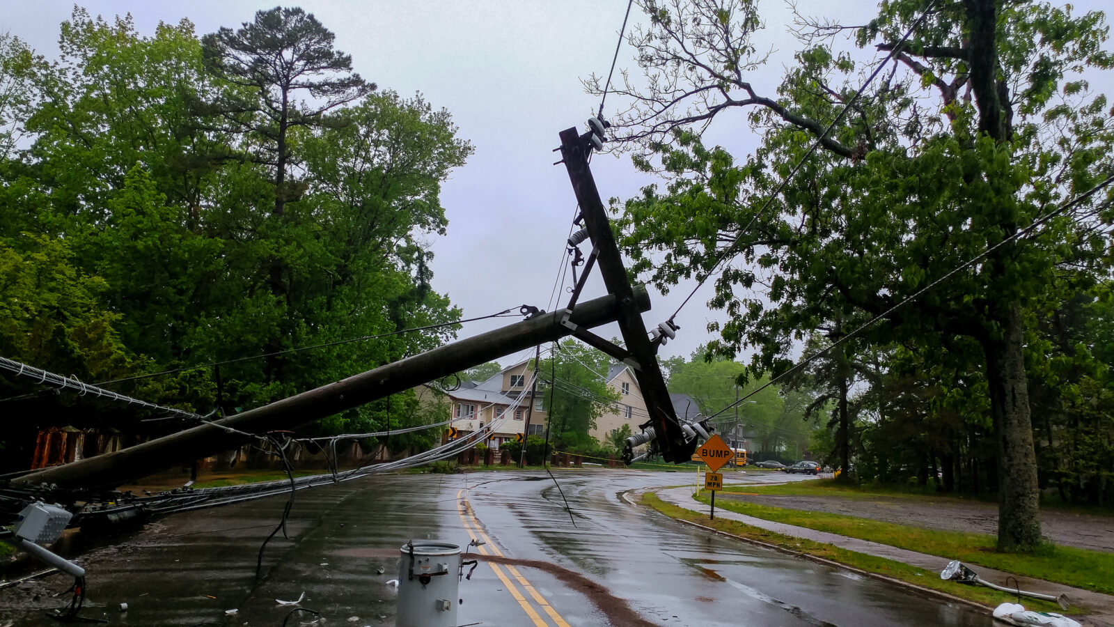A picture of a downed utility pole on a flooded road during a storm, to illustrate an LCA post on creating a weather emergency plan.